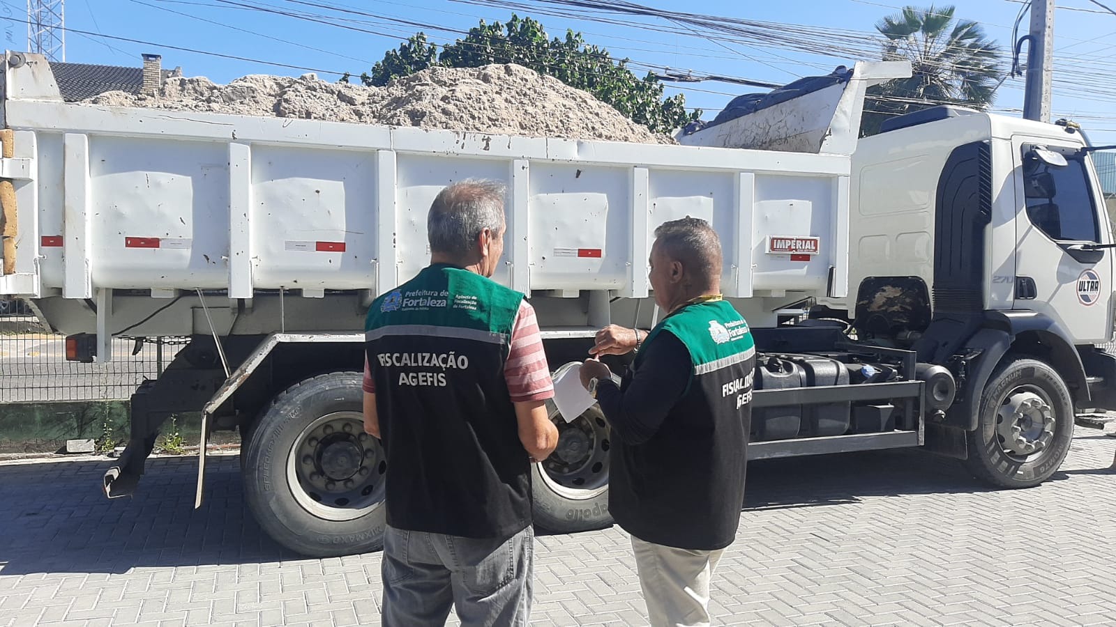homens trabalhando na frente de um caminhão cheio de lixo
